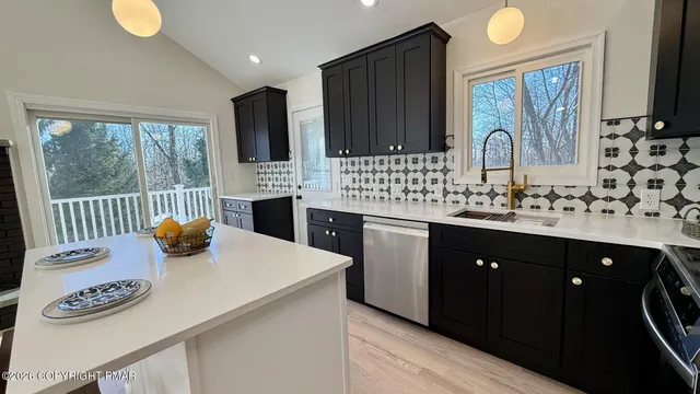 a kitchen with stainless steel appliances a sink stove and a refrigerator