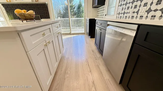 a kitchen with white cabinets and sink