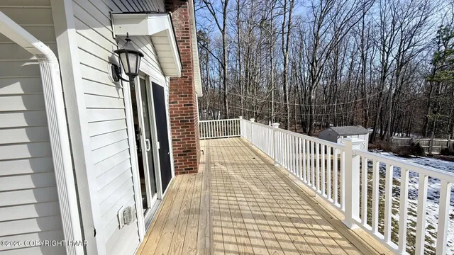 a view of a balcony with wooden floor and fence