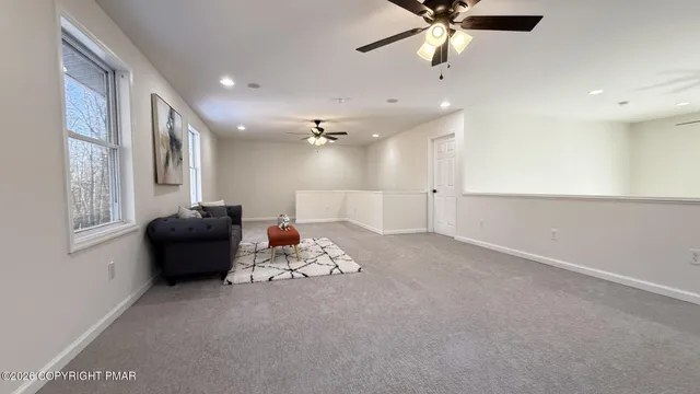 a living room with furniture and a ceiling fan