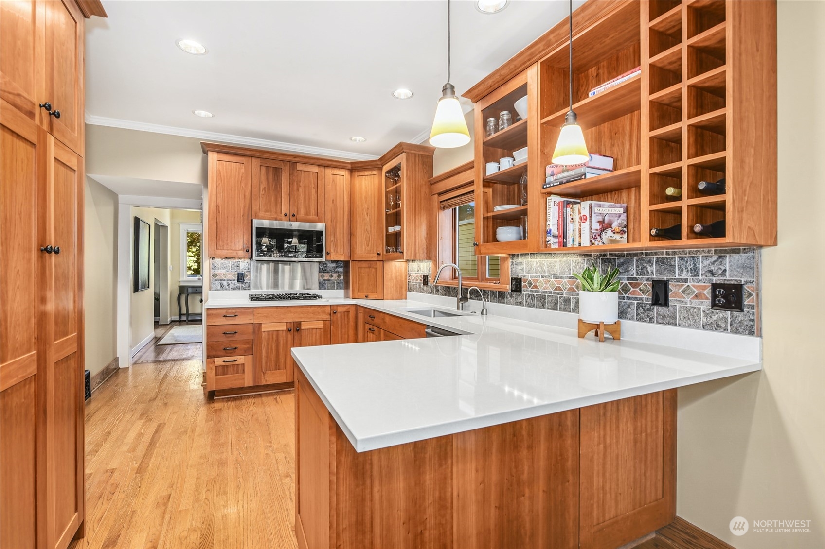 1249 18th Avenue East Seattle, WA 98112 - Photo 14 of 39 a large kitchen with stainless steel appliances a large counter top a stove a sink a refrigerator and dishwasher with wooden floor