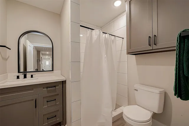 a bathroom with a toilet a sink and mirror