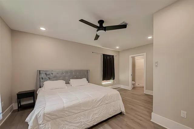 a bedroom with a bed and a ceiling fan