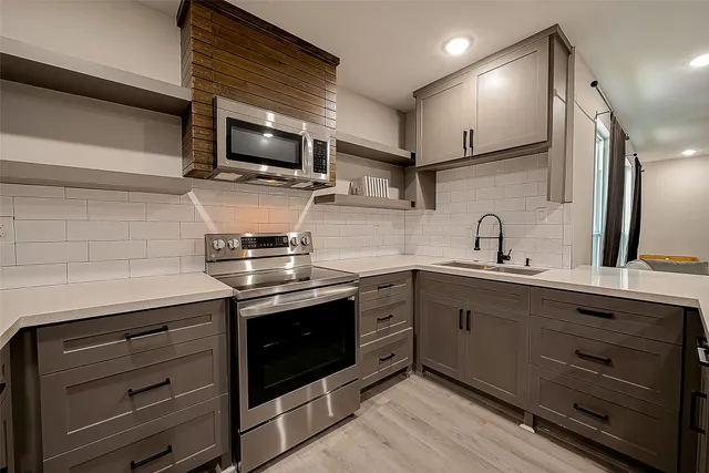 a kitchen with stainless steel appliances granite countertop a sink and a stove