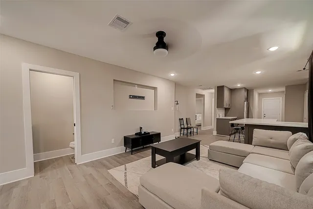 a living room with furniture and a wooden floor