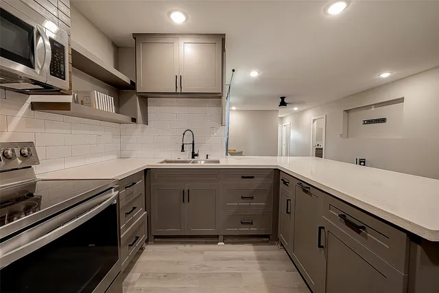 a kitchen with stainless steel appliances a sink stove and cabinets