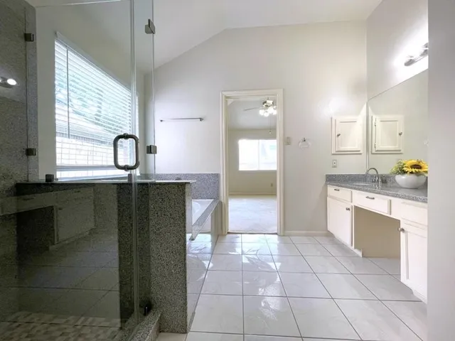 a kitchen with granite countertop a refrigerator and a stove top oven