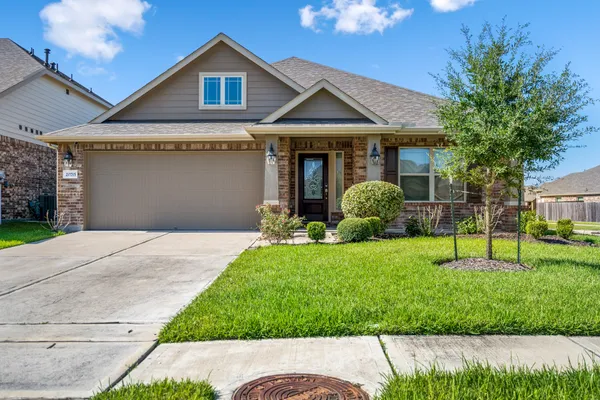 a front view of a house with a yard and potted plants