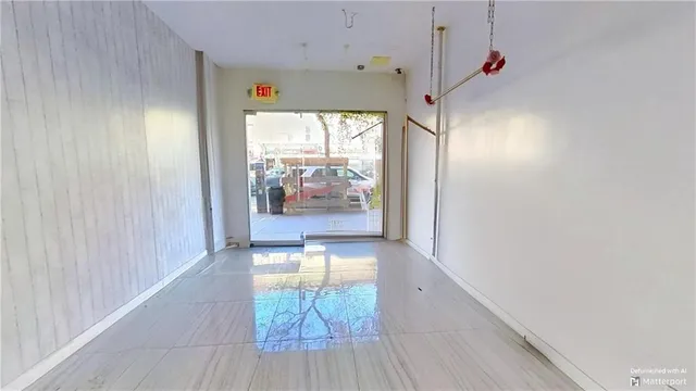 a view of a hallway with a kitchen space and a window