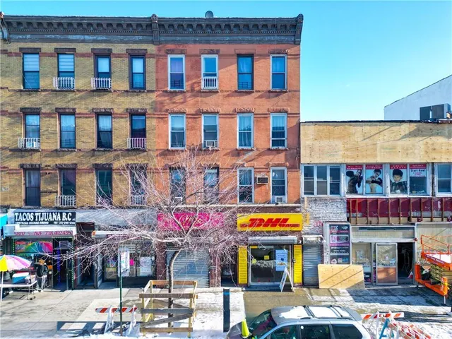 a front view of multi story building with retail shops