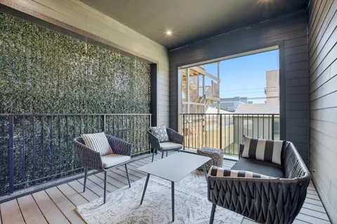 a balcony with furniture and a potted plant