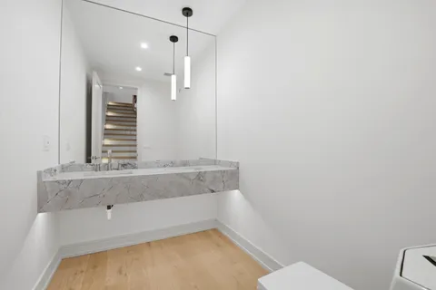 a bathroom with a granite countertop sink a toilet and mirror