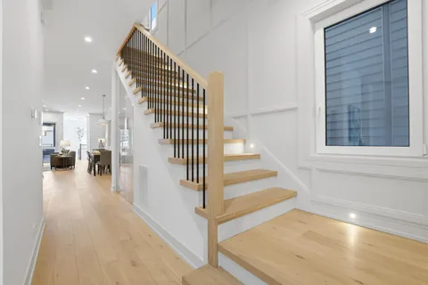 a view of a hallway with wooden floor and staircase