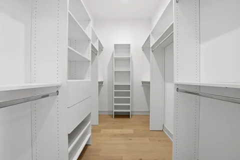 a view of walk in closet with empty racks