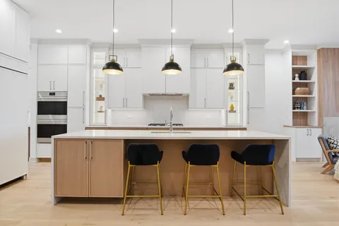 a kitchen with stainless steel appliances granite countertop a sink a stove a refrigerator and island with wooden floor