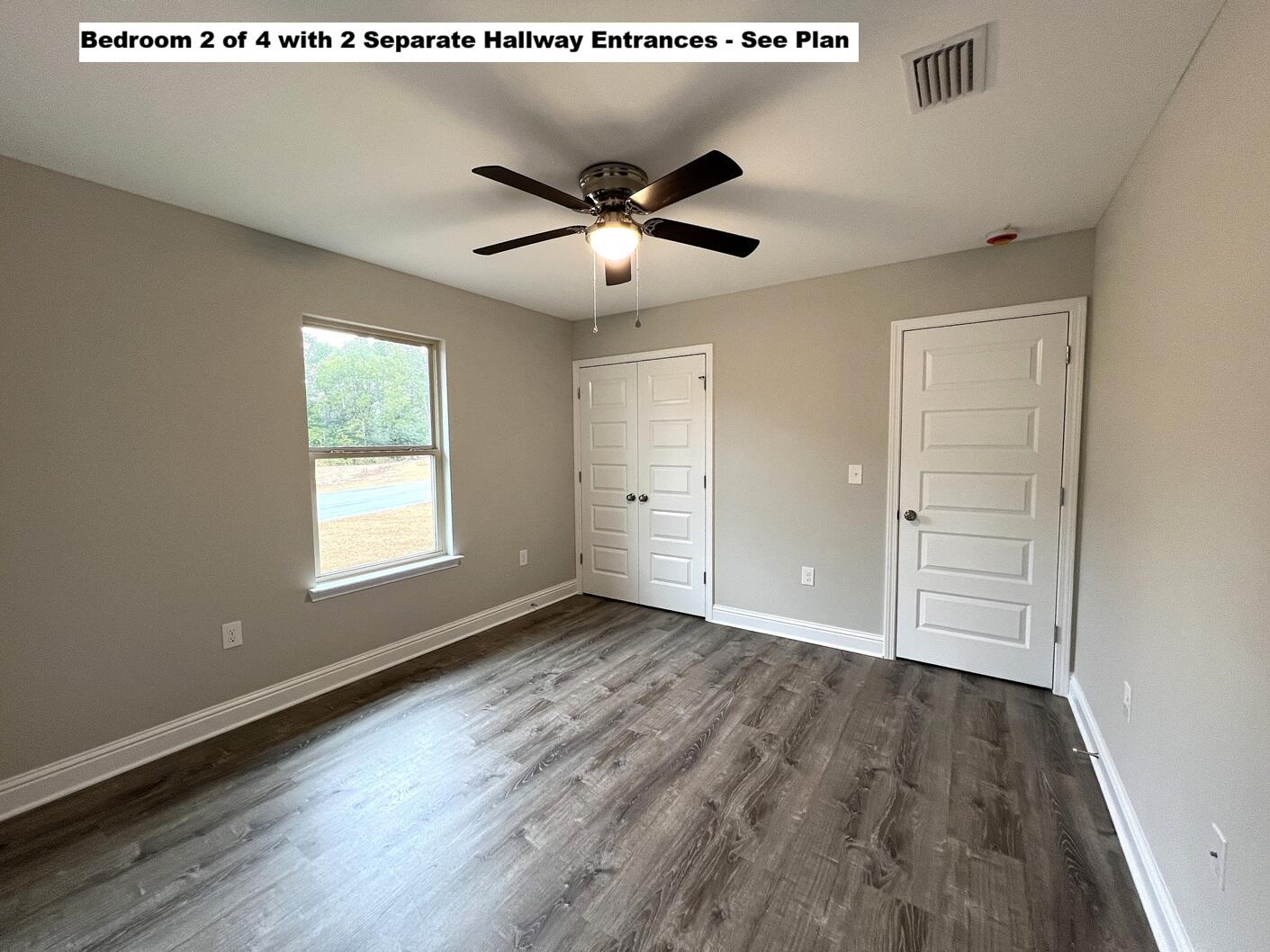 445 Scooter Cove Crestview, FL 32539 - Photo 16 of 22 an empty room with wooden floor a ceiling fan and windows