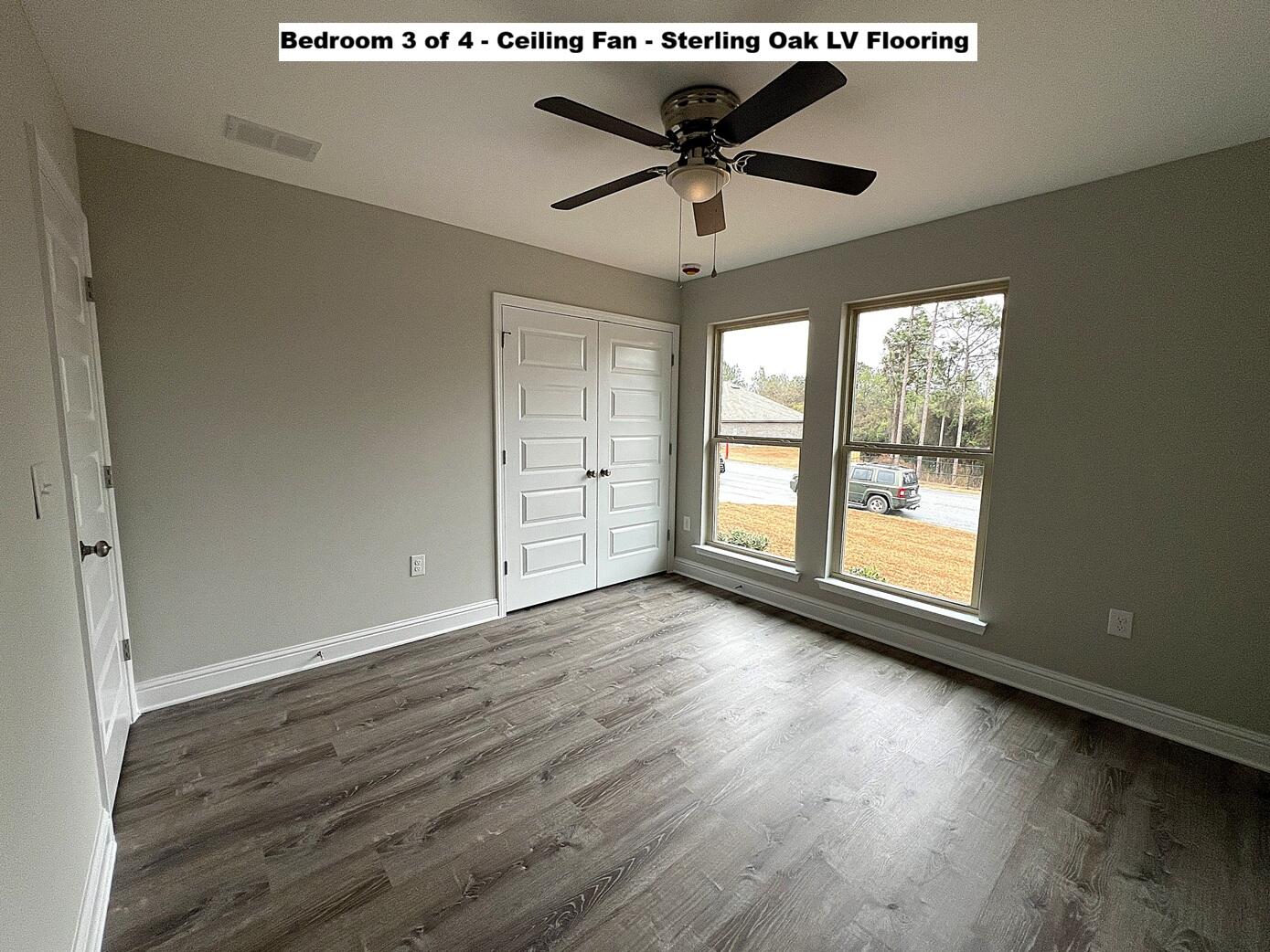 445 Scooter Cove Crestview, FL 32539 - Photo 17 of 22 an empty room with wooden floor and windows