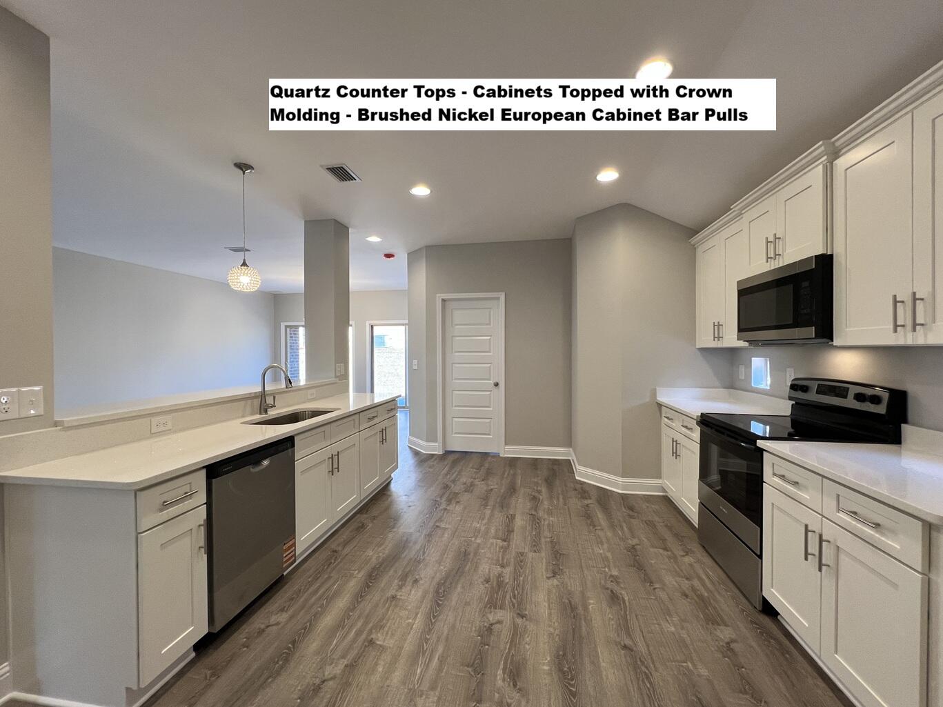 445 Scooter Cove Crestview, FL 32539 - Photo 2 of 22 a large kitchen with cabinets wooden floor and stainless steel appliances