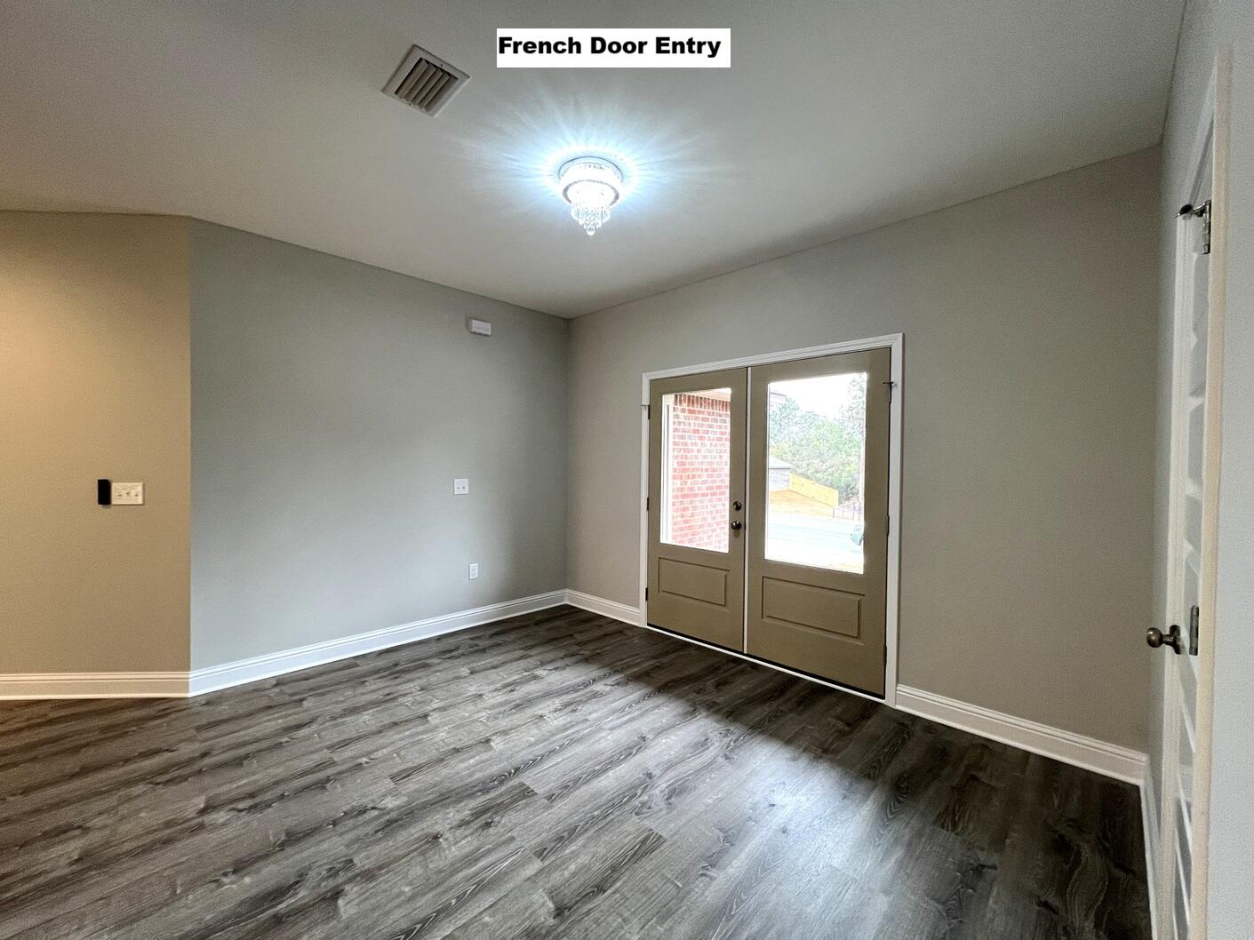 445 Scooter Cove Crestview, FL 32539 - Photo 8 of 22 an empty room with wooden floor and windows