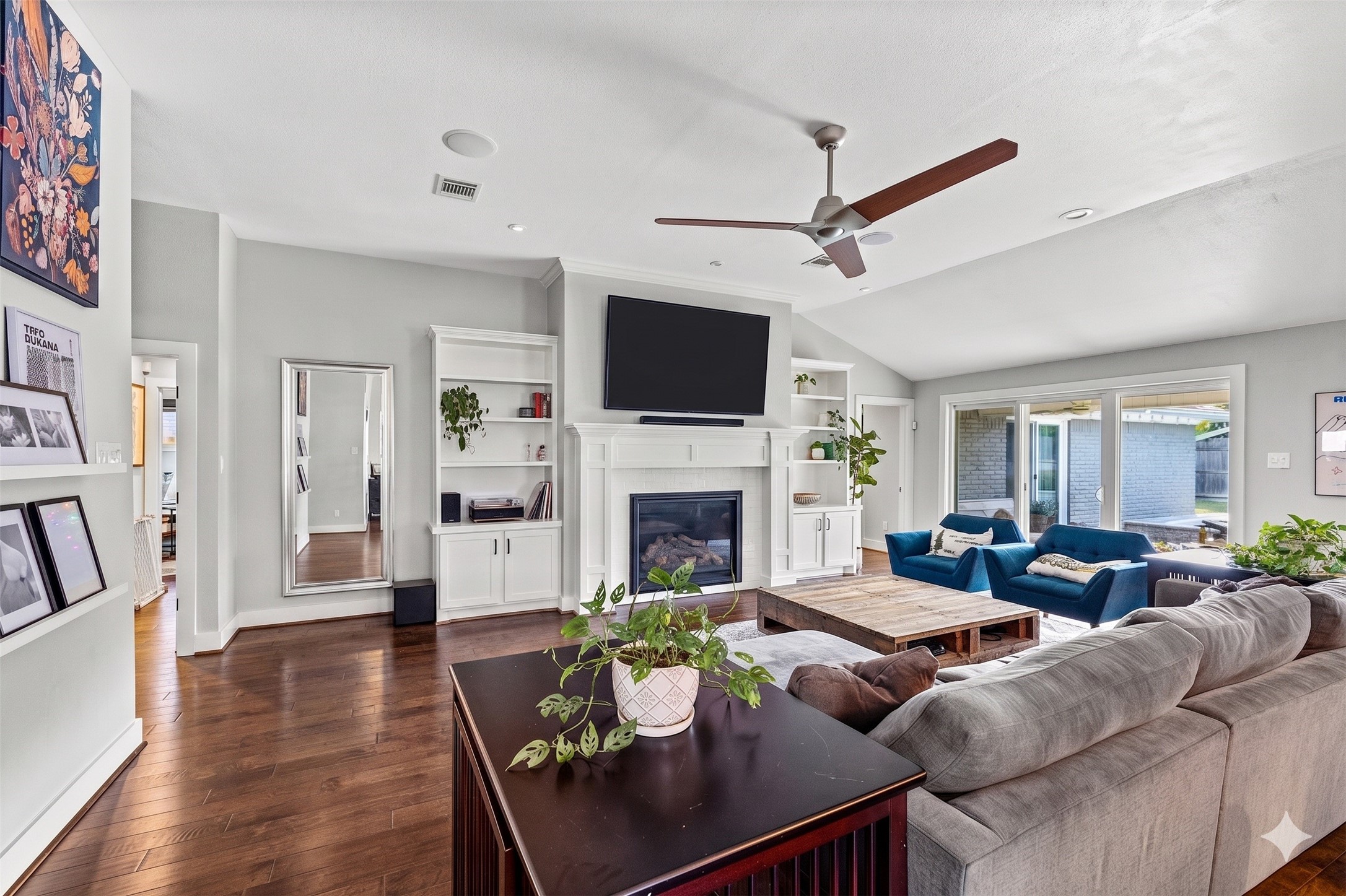 8422 Academy Street Houston, TX 77025 - Photo 12 of 47 Looking from the chefs kitchen into A warm, open living space with Charming built-ins and a glowing fireplace create the perfect family gathering spot and perfect for movie nights, celebrations, and everyday family moments.