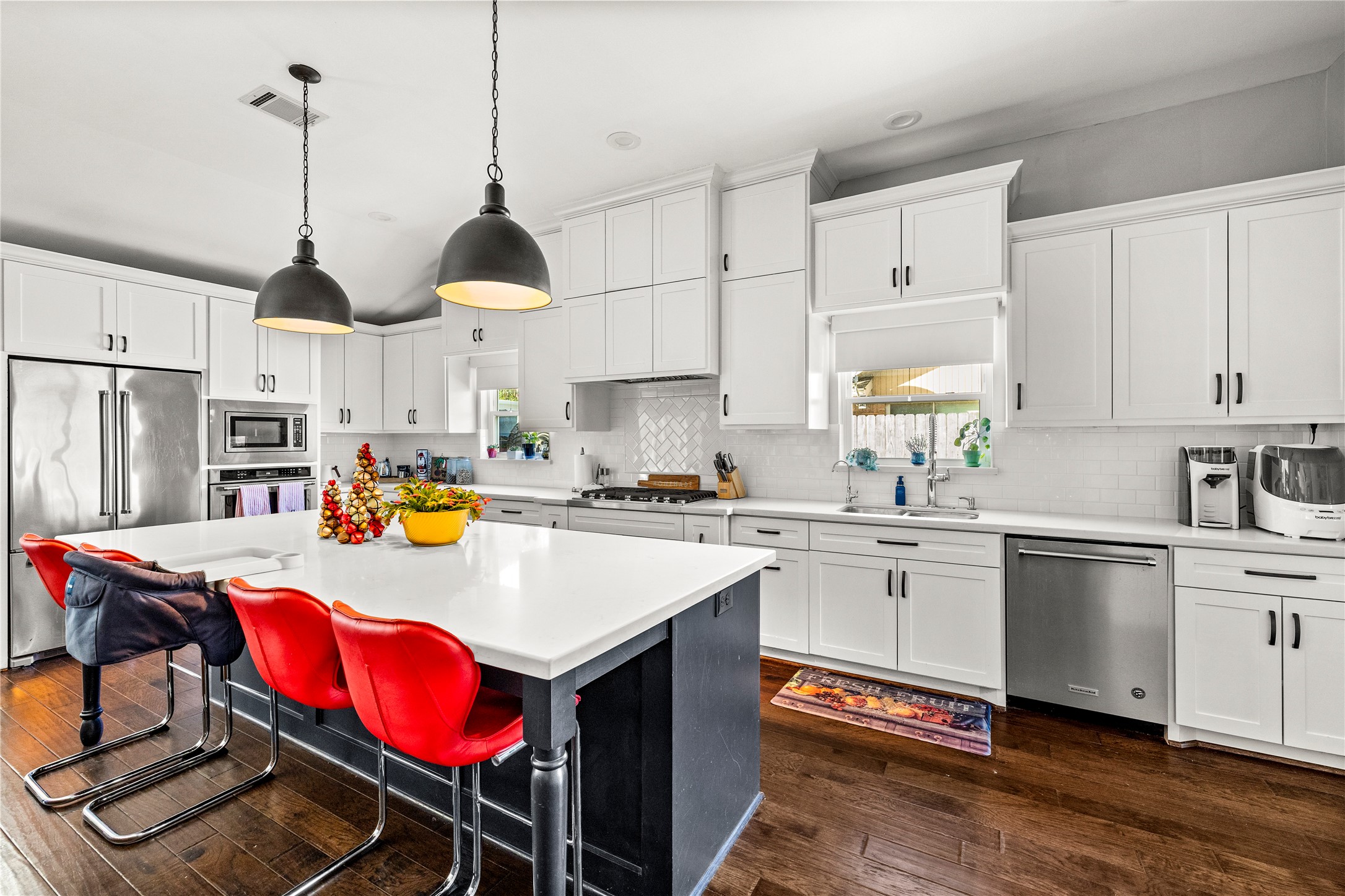8422 Academy Street Houston, TX 77025 - Photo 6 of 47 a kitchen with stainless steel appliances a stove a sink a refrigerator a center island and white cabinets