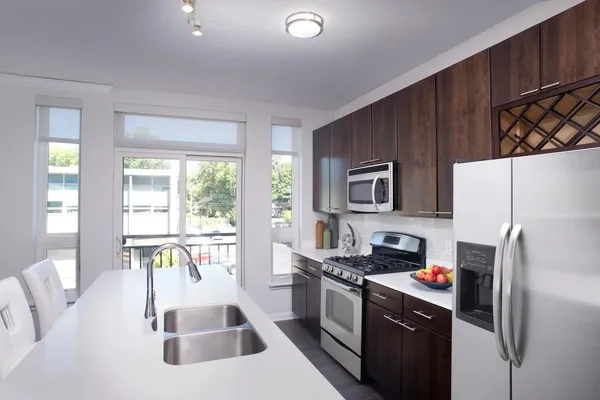 a kitchen with stainless steel appliances granite countertop a refrigerator and a stove top oven