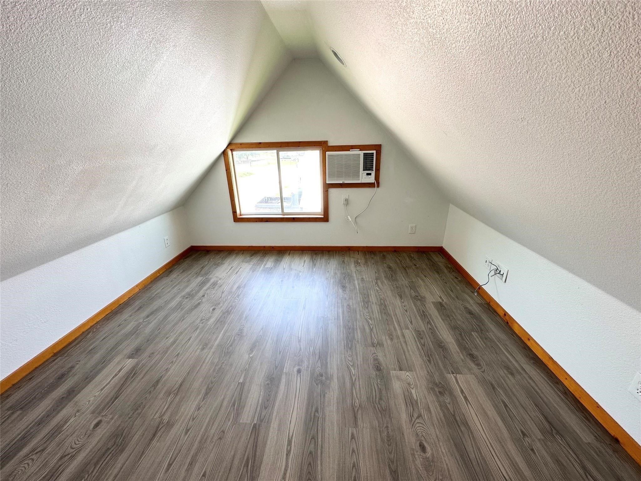 403 Free Timber Lane, Unit 3 Stockdale, TX 78160 - Photo 4 of 6 an empty room with wooden floor and windows