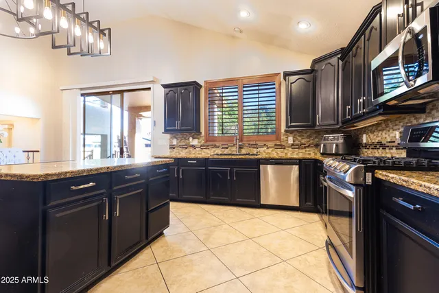 a kitchen with stainless steel appliances granite countertop a stove a sink dishwasher and a refrigerator