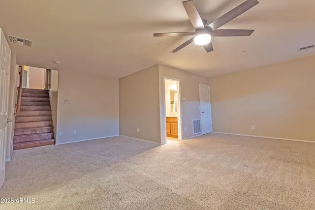 an empty room with closet and a ceiling fan