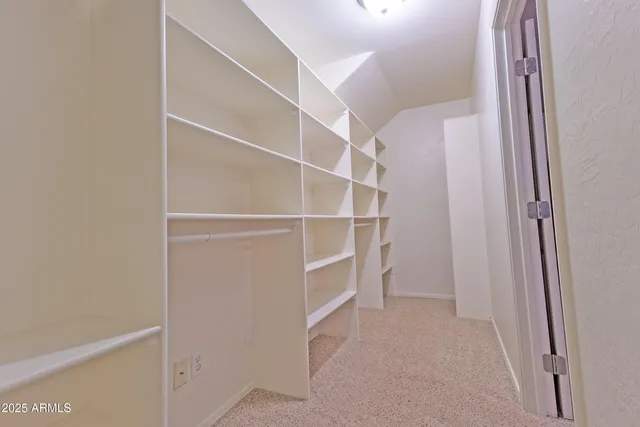 a view of walk in closet with empty racks
