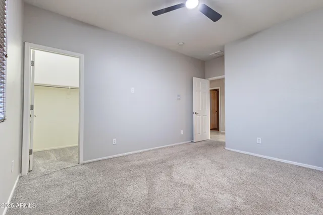 an empty room with a ceiling fan and a window