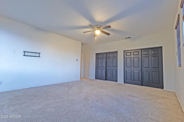 a view of empty room with ceiling fan