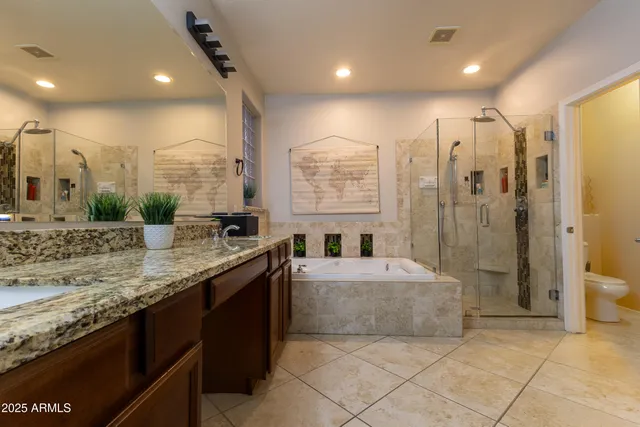 a bathroom with a granite countertop sink a toilet a mirror and shower