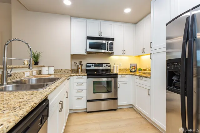 a kitchen with granite countertop stainless steel appliances and cabinets