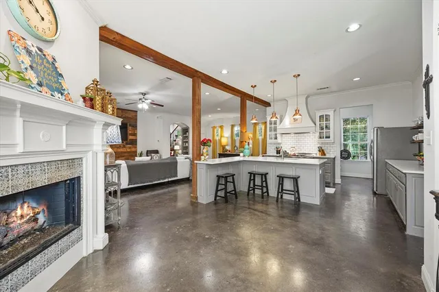 a living room with furniture a fireplace and kitchen view