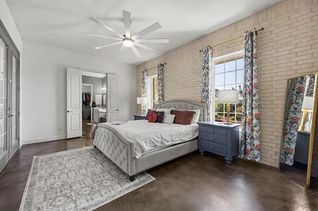 a spacious bedroom with a large bed and a chandelier