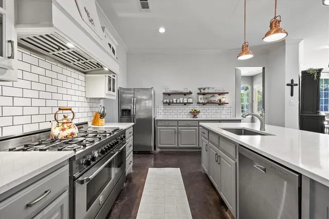 a kitchen with stainless steel appliances a sink stove and refrigerator