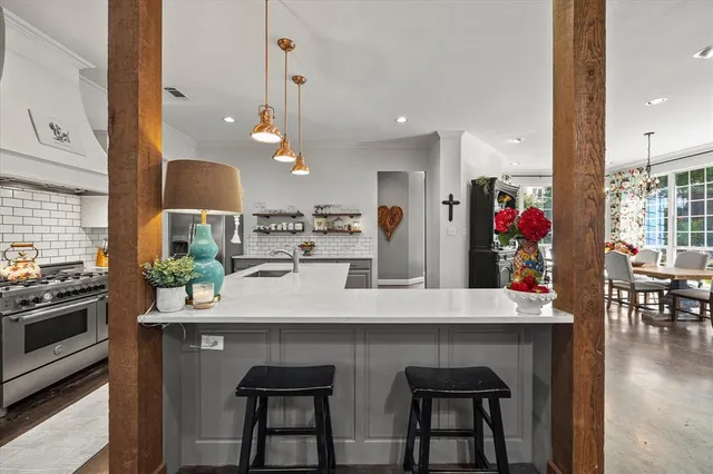 a kitchen with stainless steel appliances kitchen island a table and chairs in it
