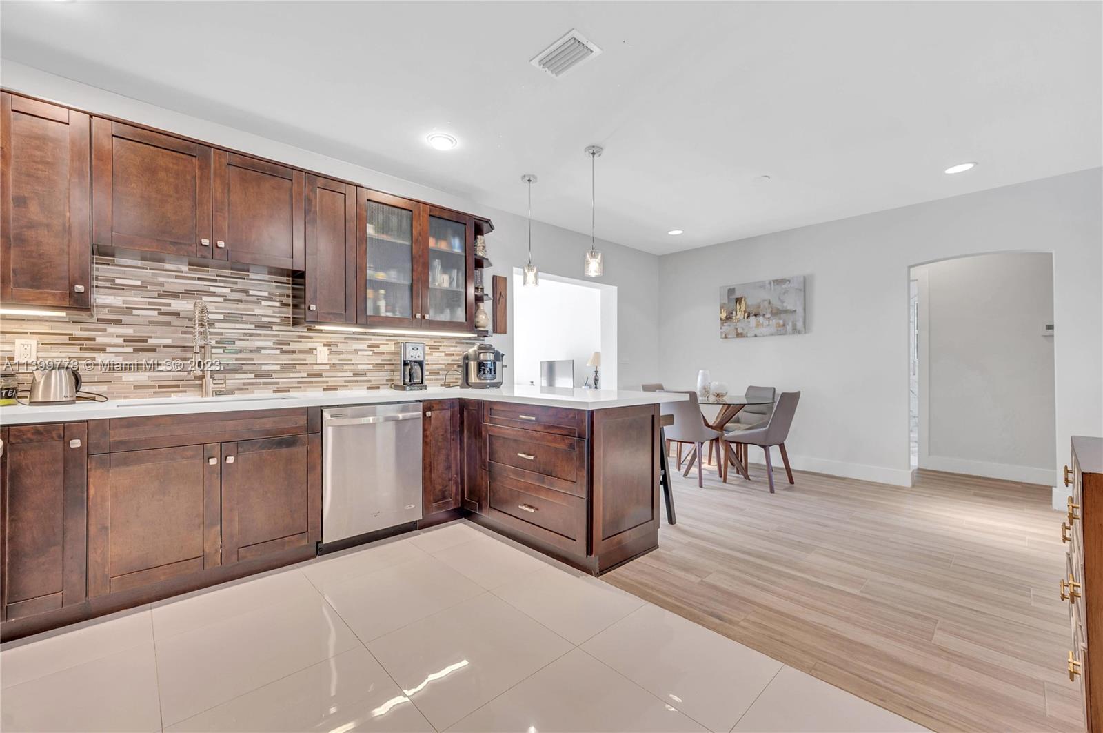 801 Southwest 28th Road Miami, FL 33129 - Photo 13 of 40 a kitchen with stainless steel appliances kitchen island granite countertop a stove a sink a dining table and chairs