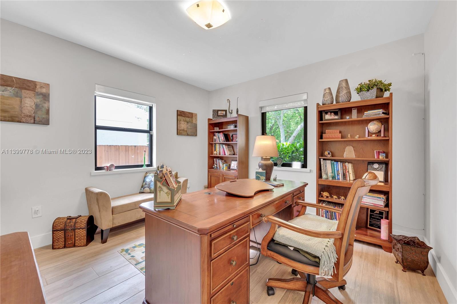 801 Southwest 28th Road Miami, FL 33129 - Photo 27 of 40 a view of a workspace with furniture and a bookshelf