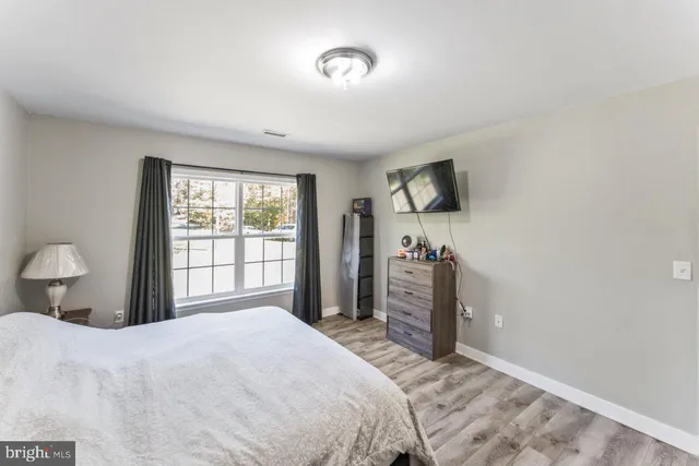 a bedroom with a bed and a flat tv screen on dresser