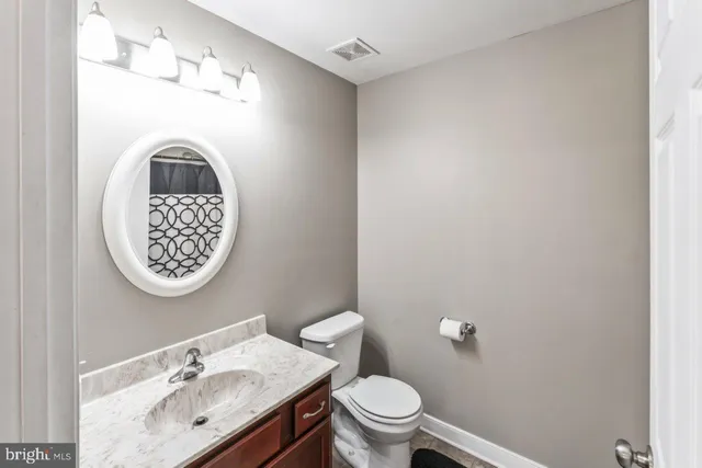 a bathroom with a sink mirror and toilet