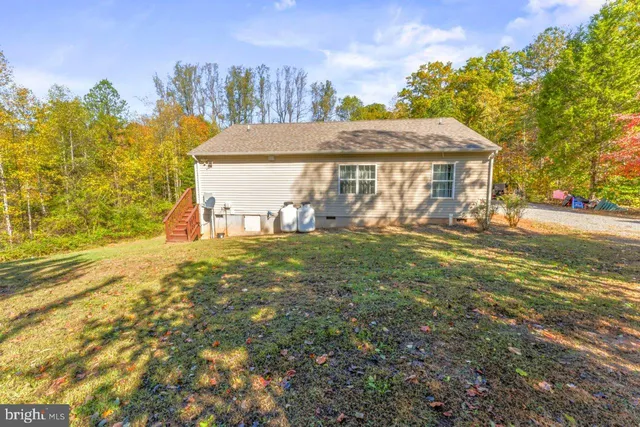 a view of a house with backyard and a tree