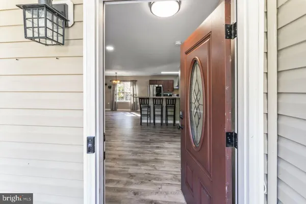 a hallway with wooden floor and livingroom view