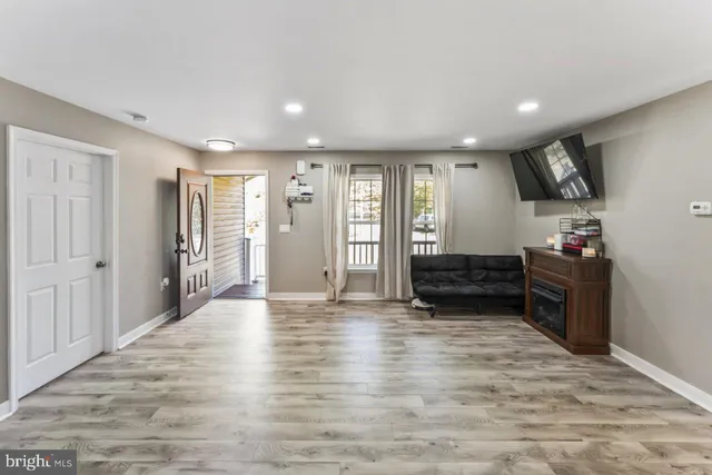 a view of empty room with wooden floor and window