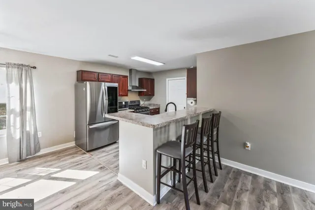 a kitchen that has a dining table chairs stainless steel appliances and cabinets