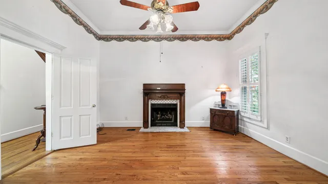 a view of a livingroom with wooden floor and a ceiling fan