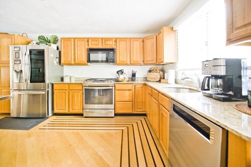 16 Warren Avenue Newton, MA 02465 - Photo 34 of 42 a kitchen with stainless steel appliances granite countertop a sink and a stove