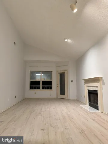 a view of an empty room with a fireplace and a window