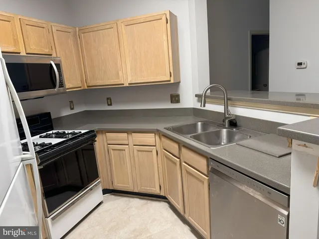 a kitchen with stainless steel appliances granite countertop a sink and a stove